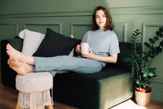 Serene Modern Lifestyle - Confident, Stylish Woman in Cozy Home Setting with Tea Coffee. Elegant Portrait of Tranquil Home Comfort and Relaxed Confidence.