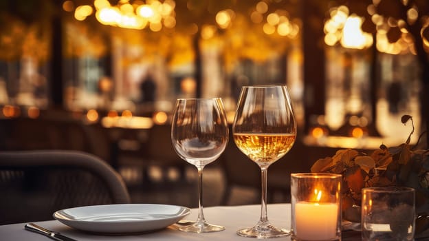 Dinner in a chic restaurant, on the terrace in the fresh air, by candlelight with a glass of champagne or wine, with beautiful glowing lights. Valentine's day, newlyweds, engagement, holiday, birthday, wedding, anniversary, surprise, date.