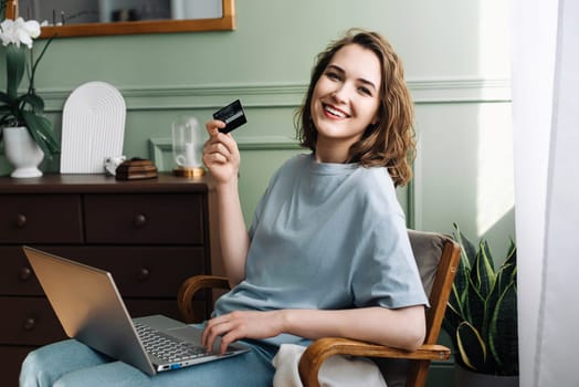 Online Shopping Joy. Young Woman Delighted with Credit Card and Laptop. Cheerful Woman Making Purchases Online with Credit Card and Laptop. Happy Shopper.