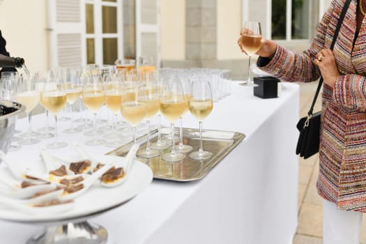 A wedding guest takes champagne and waiter pouring champagne