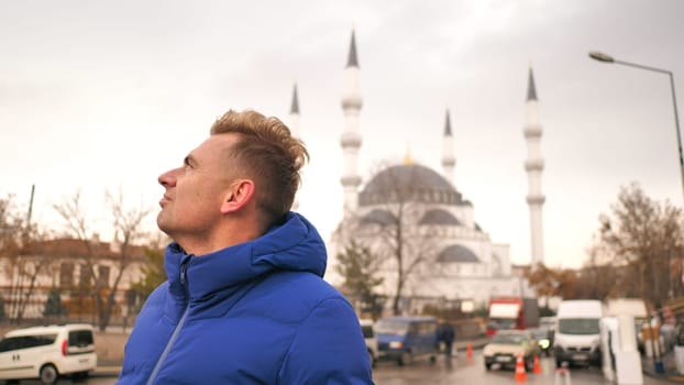 Tourist in the winter against the background of a mosque in Ankara