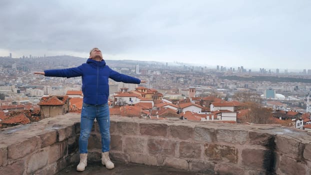 A guy with spread arms admires the capital of Turkey, Ankara