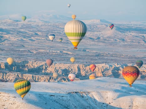 Colorful balloons over volcanic rocks in Cappadocia. Turkey