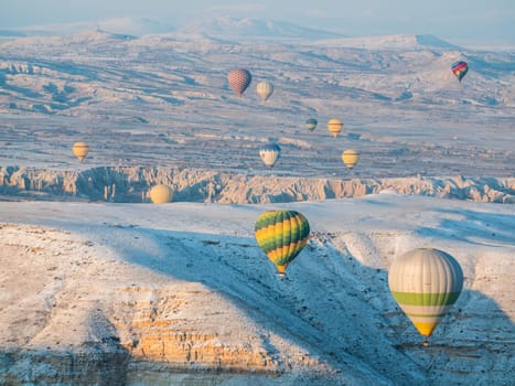 Colorful balloons over volcanic rocks in Cappadocia. Turkey