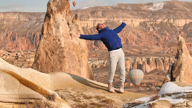A young guy is enjoying the mountains in Cappadocia. Turkey