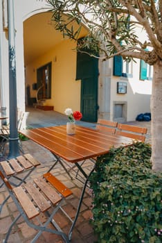 Empty cafe terrace with white table and chair. exterior of the cafe restaurant. interior Street cafe. Cozy street with flowers and French-style cafe table. Decor facade of coffeehouse with bike. Table on a summer terrace with cake and teapot. Garden table and chairs