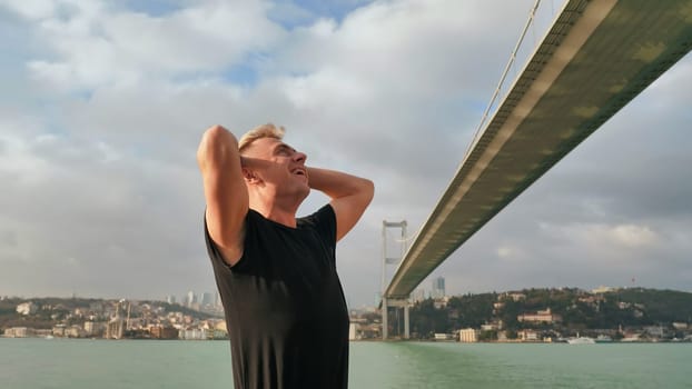 A young man admires the huge bridge over the Bosphorus in Istanbul. Turkey