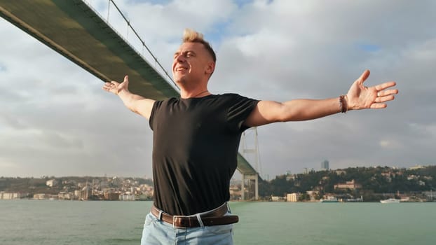 A young man admires the huge bridge over the Bosphorus in Istanbul. Turkey