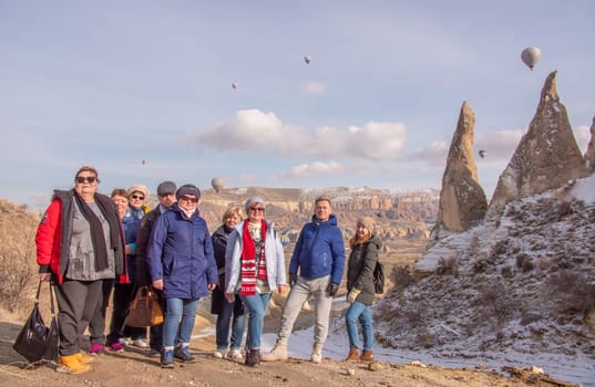 Russian tourists posing in the Valley of Love in Goreme Cappadocia Turkey during the freezing winter months