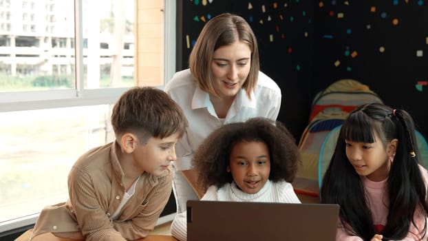 Smart teacher checking student answer while learner using laptop to doing homework, analysis data, programing engineering code and prompt, studying computer system at STEM technology class. Erudition.