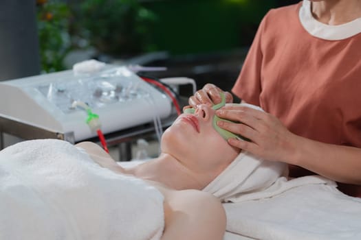 Attractive caucasian woman receive electrical facial treatment. Beautiful girl lies on spa bed while having medical treatment from professional doctor from medical spa center. Tranquility.