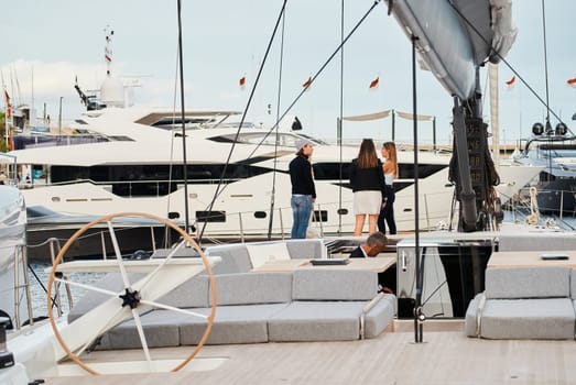 Monaco, Monte Carlo, 29 September 2022 - Invited wealthy clients inspect mega yachts at the largest fair exhibition in the world yacht show MYS, port Hercules, yacht brokers, sunny weather. High quality photo