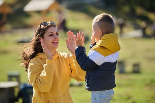 A mother and son create cherished memories as they playfully engage in outdoor activities, their laughter echoing the joy of shared moments and the bond between parent and child.