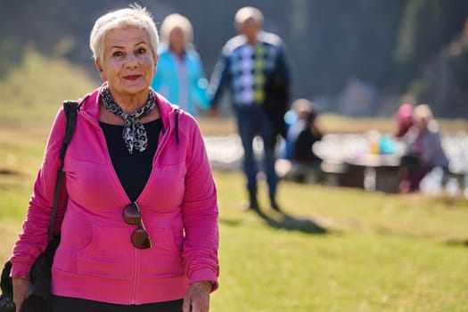 A senior woman finds serenity and wellness as she strolls through nature, illustrating the beauty of maintaining an active and health-conscious lifestyle in her golden years.
