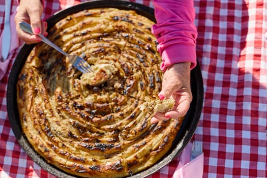 Exquisitely prepared, this traditional Bosnian dish showcases a mouthwatering pie under its lid, perfectly baked and ready to delight guests, embodying the rich culinary heritage and inviting flavors of Bosnian cuisine.