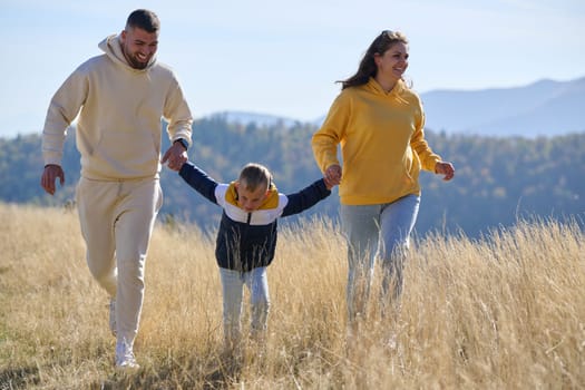 A modern family, along with their son, revels in the joy of a muddy day in nature, running and playing together, encapsulating the beauty of a healthy and active lifestyle.