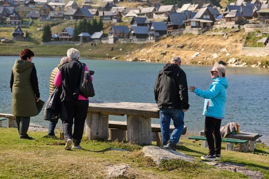 A family shares delightful moments with their friends amid the stunning landscapes of mountains, lakes, and winding paths, promoting a healthy lifestyle and the joy of familial bonds in the embrace of nature's beauty.