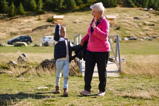 Elderly grandmother and her grandchild share a leisurely stroll through nature, enveloped in the beauty of their surroundings, fostering a bond that transcends generations.