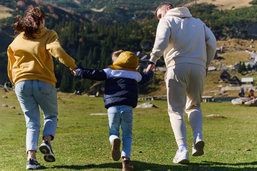 A modern family, along with their son, revels in the joy of a muddy day in nature, running and playing together, encapsulating the beauty of a healthy and active lifestyle.