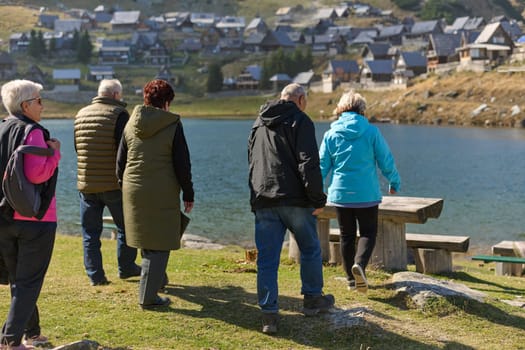 A family shares delightful moments with their friends amid the stunning landscapes of mountains, lakes, and winding paths, promoting a healthy lifestyle and the joy of familial bonds in the embrace of nature's beauty.