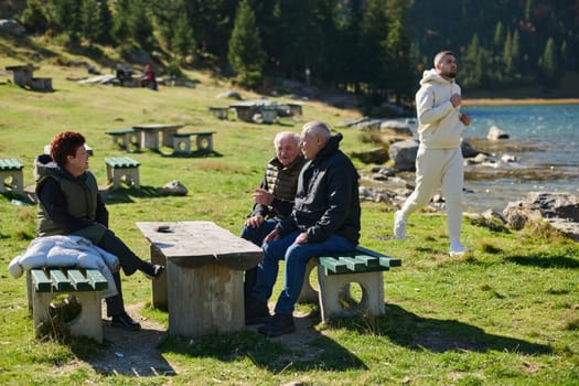 A family shares delightful moments with their friends amid the stunning landscapes of mountains, lakes, and winding paths, promoting a healthy lifestyle and the joy of familial bonds in the embrace of nature's beauty.