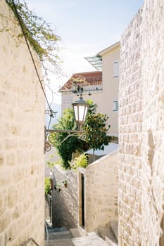 Narrow street with descending steps between old stone fences. High quality photo