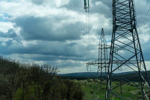 High voltage towers with sky background. Power line support with wires for electricity transmission. High voltage grid tower with wire cable at distribution station. Energy industry, energy saving.