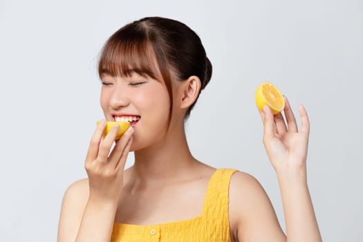Young beautiful girl with clean perfect skin with lemon close-up. Cosmetics and care for young skin