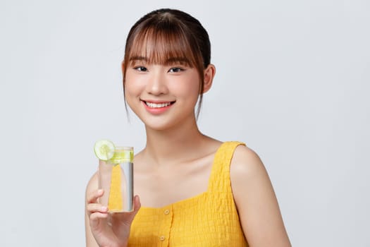 Calm youthful lady refreshing herself with lemon water