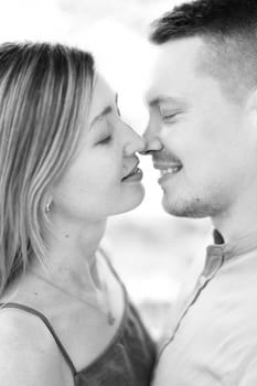 Smiling man and woman almost kiss with their eyes closed. Black and white photo. High quality photo