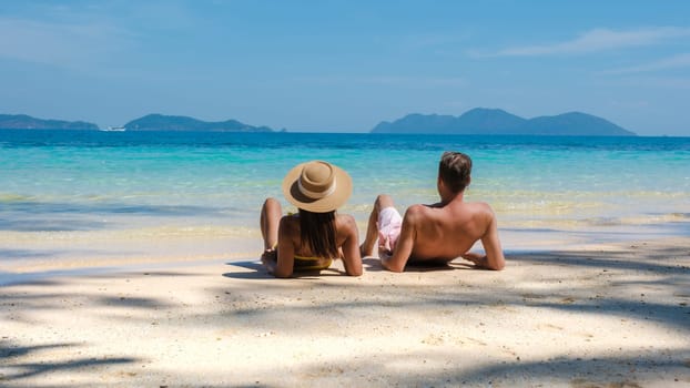 Koh Wai Island Trat Thailand is a tinny tropical Island near Koh Chang. a young couple of men and women on a tropical beach during a luxury vacation in Thailand, couple lying down on the beach