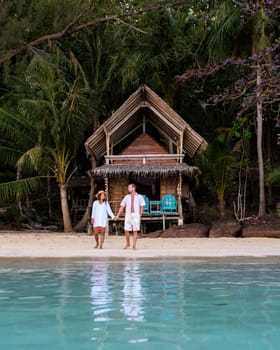 Koh Wai Island Trat Thailand is a tinny tropical Island near Koh Chang. wooden bamboo hut bungalow on the beach. a young couple of men and woman on a tropical Island in Thailand in the evening