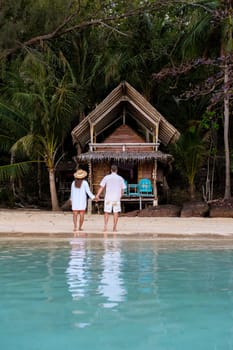Koh Wai Island Trat Thailand is a tinny tropical Island near Koh Chang. wooden bamboo hut bungalow on the beach. a young couple of men and woman on a tropical Island in Thailand in the evening