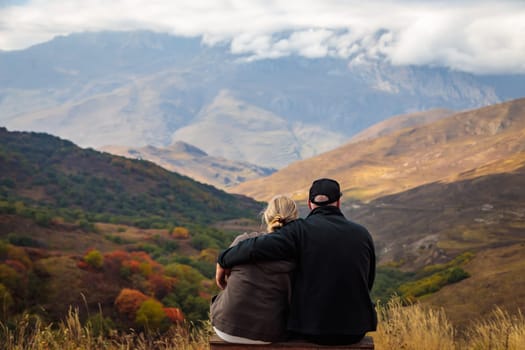 Young couple in embrace, admiring the beauty of the mountains surrounding them