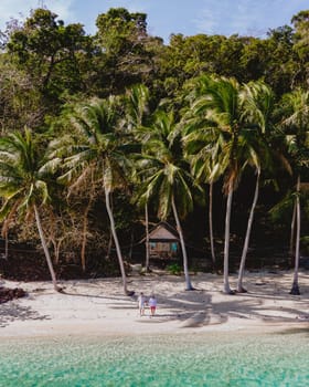 Koh Wai Island Trat Thailand is a tinny tropical Island near Koh Chang. wooden bamboo hut bungalow on the beach. a young couple of men and woman on a tropical Island in Thailand in the morning light