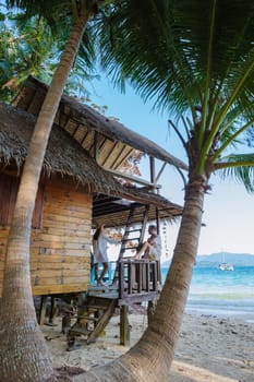 Koh Wai Island Trat Thailand a tinny tropical Island near Koh Chang. wooden bamboo hut on the beach. a young couple of men and woman on a tropical Island in Thailand looking out over the ocean