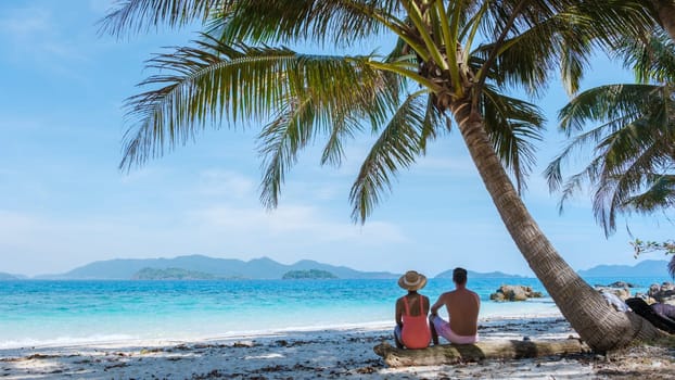 Koh Wai Island Trat Thailand near Koh Chang. a young couple of men and women on a tropical beach during a luxury vacation in Thailand, men and woman relaxing under a palm tree at a natural beach