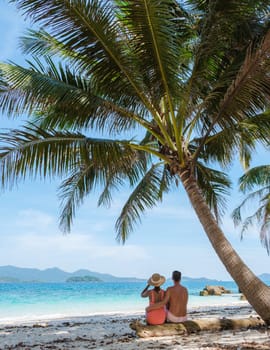 Koh Wai Island Trat Thailand is a tinny tropical Island near Koh Chang. a young couple of men and women on a tropical beach during a luxury vacation in Thailand, couple sitting under a palm tree