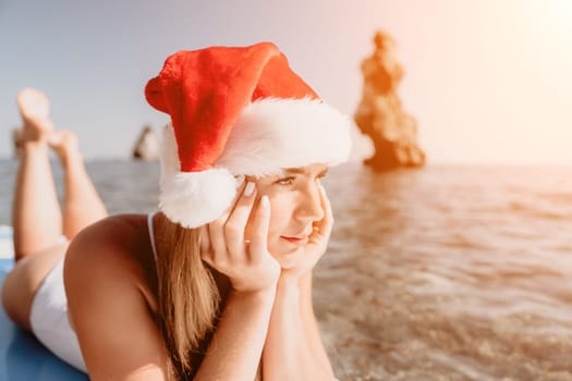 Close up shot of happy young caucasian woman looking at camera and smiling. Cute woman portrait in bikini posing on a volcanic rock high above the sea