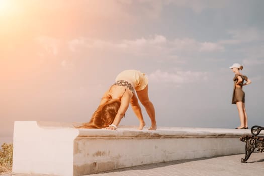 Woman park yoga. Side view of free calm bliss satisfied woman with long hair standing in morning park with yoga position against of sky by the sea. Healthy lifestyle outdoors in park, fitness concept