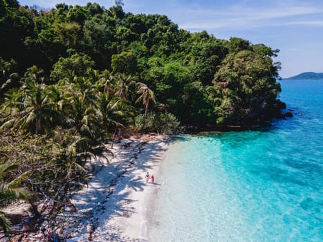 Drone aerial view at Koh Wai Island Trat Thailand is a tinny tropical Island near Koh Chang. A young couple of men and women walking on a tropical beach during a luxury vacation in Thailand