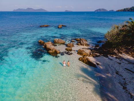 Drone aerial view at Koh Wai Island Trat Thailand is a tinny tropical Island near Koh Chang. a young couple of men and women relaxing on a tropical beach during a luxury vacation in Thailand