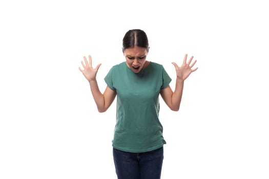 young slender woman dressed in a green basic t-shirt with a mockup looks confused.