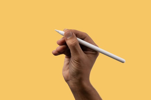 Black male hand holding an smart pencil isolated on yellow. High quality photo