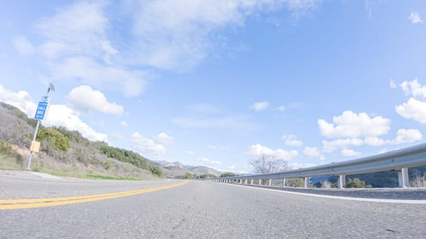 Vehicle is cruising along the Cuyama Highway under the bright sun. The surrounding landscape is illuminated by the radiant sunshine, creating a picturesque and inviting scene as the car travels through this captivating area.