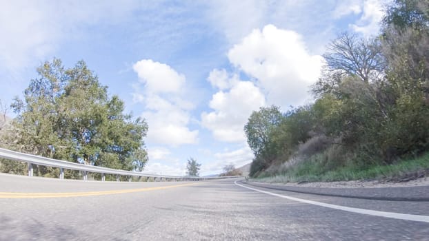 Vehicle is cruising along the Cuyama Highway under the bright sun. The surrounding landscape is illuminated by the radiant sunshine, creating a picturesque and inviting scene as the car travels through this captivating area.