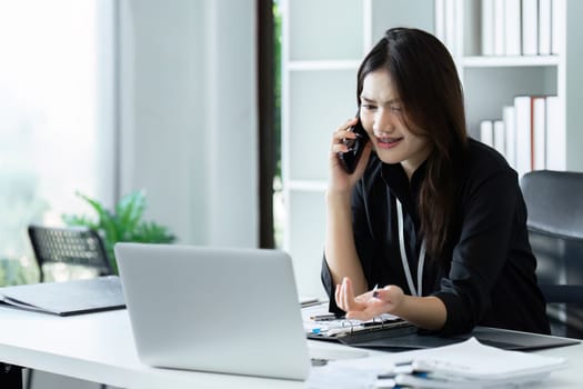 Businesswoman on the phone and using laptop at office. Businesswoman professional talking on mobile phone.