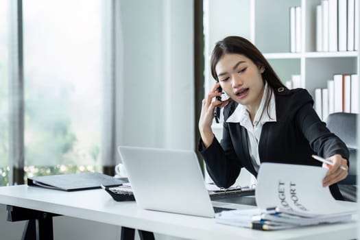 Businesswoman on the phone and using laptop at office. Businesswoman professional talking on mobile phone.