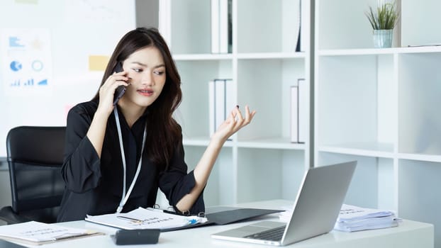 Businesswoman on the phone and using laptop at office. Businesswoman professional talking on mobile phone.