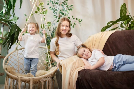 Happy family young mother babysitter relax having fun with cute little children daughters in living room at home